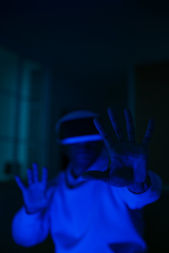 Home Person immersed in a dark room with virtual reality gear, experiencing digital simulation.